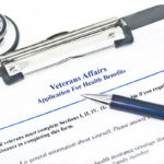 Veteran Affairs Health Benefits Application with pen and stethoscope on side