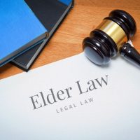 Elder Law. Document with label. Desk with books and judges gavel in a lawyer's office.